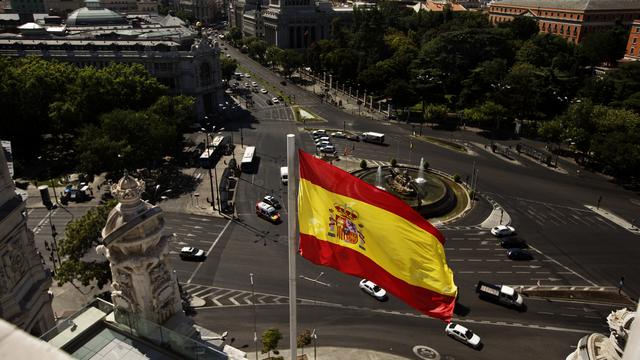 Le drapeau espagnol flotte à Madrid. [Keystone - AP Photo/Daniel Ochoa de Olza]