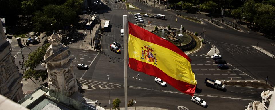 Le drapeau espagnol flotte à Madrid. [Keystone - AP Photo/Daniel Ochoa de Olza]