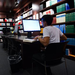 Une personne travaille dans la bibliothèque de l'IDHEAP. [Keystone - Jean-Christophe Bott]