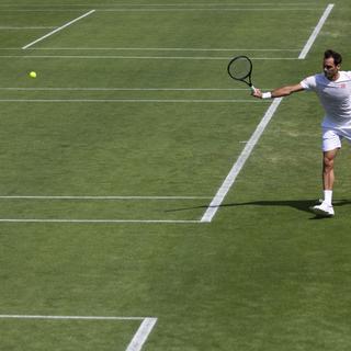 Roger Federer se prépare sur la gazon londonien avant le début des joutes à Wimbledon. [KEYSTONE - Peter Klaunzer]