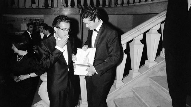 Michel Legrand (gauche) et Jacques Demy (droite) le 14 mai 1964 à Cannes, avec le "Grand Prix du Festival" pour le film "Les Parapluies de Cherbourg". [AFP]