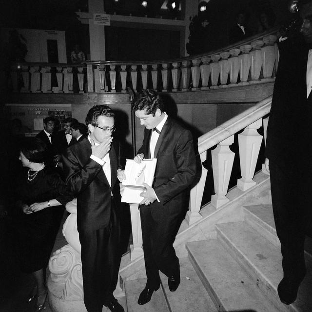 Michel Legrand (gauche) et Jacques Demy (droite) le 14 mai 1964 à Cannes, avec le "Grand Prix du Festival" pour le film "Les Parapluies de Cherbourg". [AFP]