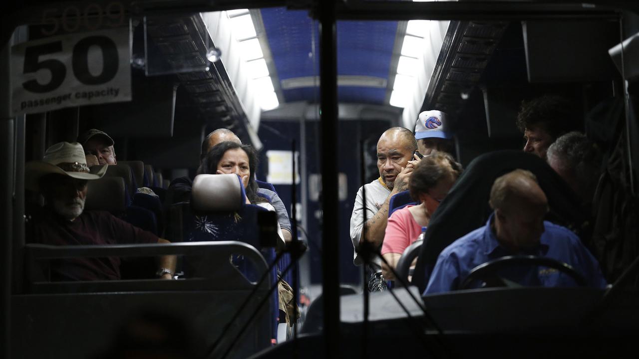 Des festivaliers sont évacués par un bus après la fusillade d'un festival de l'ail en Californie. [AP Photo - Josie Lepe]