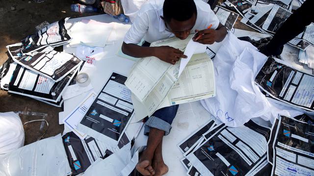 Un employé de la Commission électorale nationale indépendante examine du matériel électoral à Kinshasa. [Reuters - Baz Ratner]