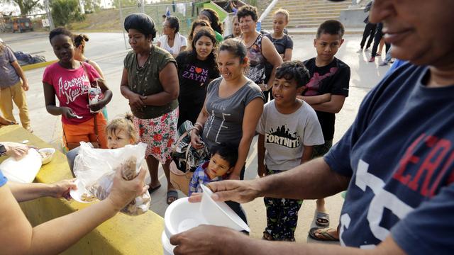 Des migrants qui cherchent à rejoindre les Etats-Unis reçoivent de la nourriture de la part de bénévoles, à Matamoros, au Mexique. [AP Photo - Eric Gay]