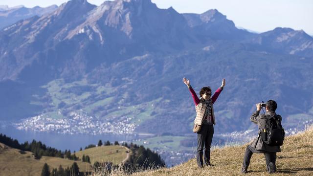 Deux touristes chinois se prenant en photo au sommet du Rigi, dans le canton de Lucerne. [Keystone - Alexandra Wey]