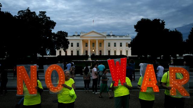 Des manifestants brandissent des lettres formant l'expression "No war" ("Pas de guerre"), ce jeudi soir 20 juin devant la Maison Blanche à Washington. [AP Photo - Jacquelyn Martin]