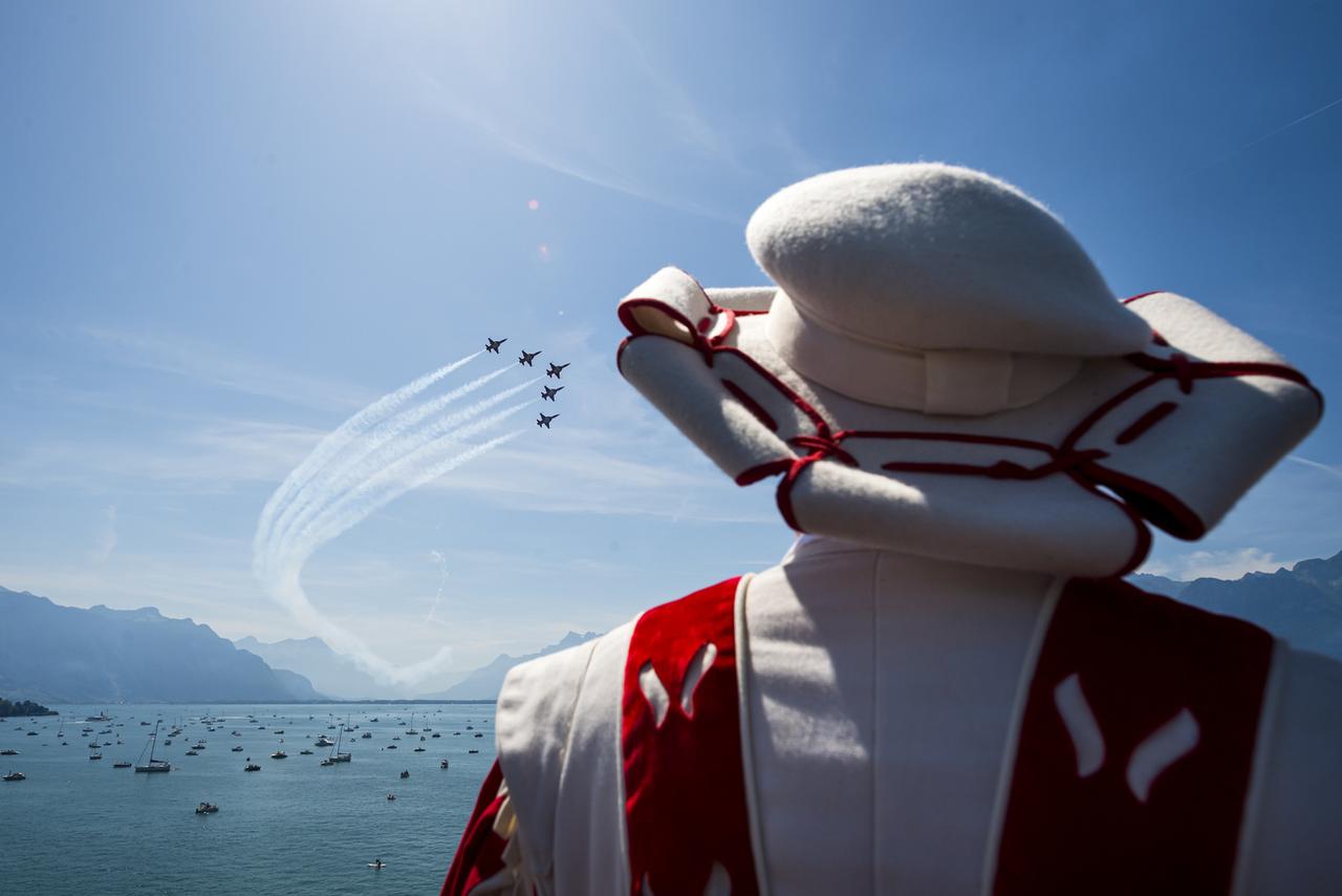 La Patrouille suisse se produit devant un membre de la compagnie des Cent-Suisses à Vevey. [Keystone - Jean-Christophe Bott]