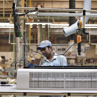 Un ouvrier assemble un climatiseur dans une usine en Inde. [Reuters - Adnan Abidi]