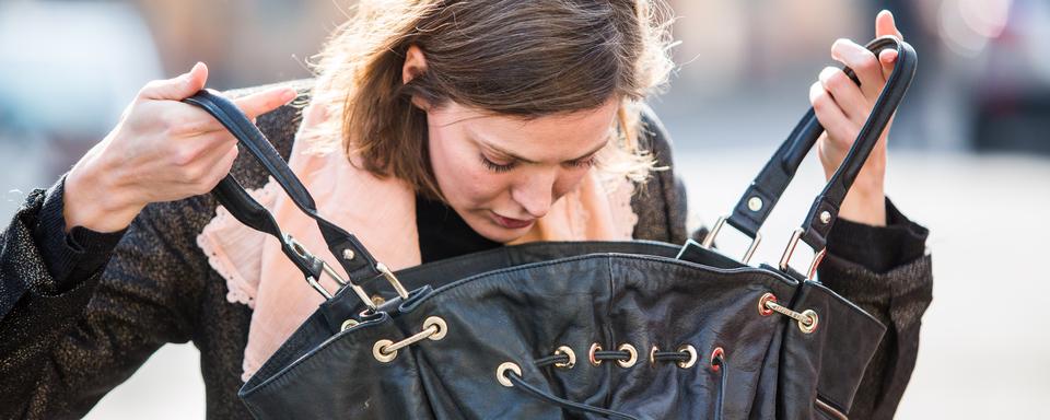 Une femme fouille son sac. [AFP - Garo / Phanie]