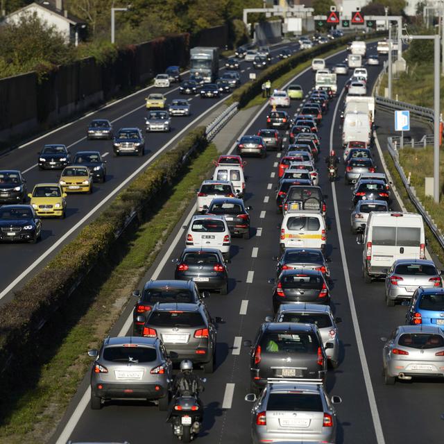 Des voitures circulent sur trois pistes dont la bande d'arrêt d'urgence sur l'autoroute Genève-Lausanne, en octobre 2014. [Keystone - Laurent Gillieron]