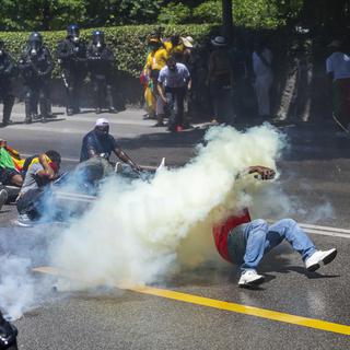 La police genevoise repousse les manifestants camerounais avec des gaz lacrymogènes et un canon à eau. [Keystone - Martial Trezzini]