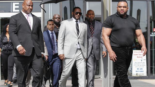 R.Kelly (centre, costume clair), sort d'une audience dans un tribunal de Chicago, le 6 juin 2019. [AFP - KAMIL KRZACZYNSKI]