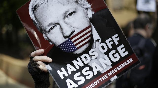 Un protestataire brandit un message de soutien à Julian Assange devant le tribunal de Londres qui jugeait le fondateur de WikiLeaks le 1er mai 2019. [Keystone - AP Photo/Matt Dunham]