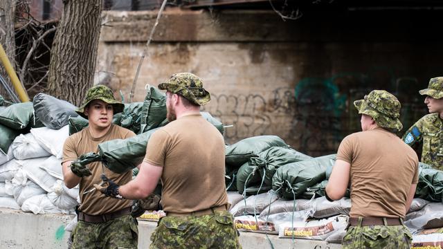 Des militaires canadiens protègent les bâtiments à Laval, à l'aide de sacs de sables, lors d'inondations violentes dans l'est du pays. [AFP - Martin Oullet-Diotte]