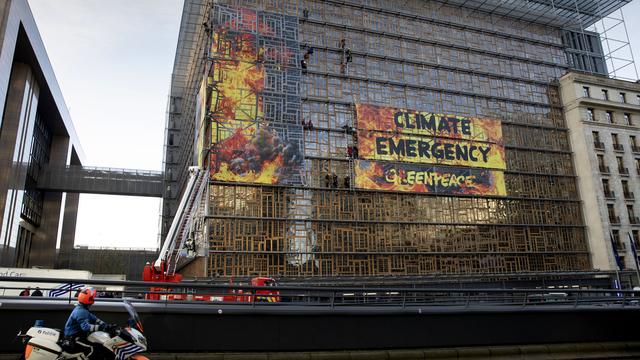 Des militants de Greenpeace ont déployé des banderoles sur le nouveau bâtiment du Conseil européen à Bruxelles. [Keystone/AP Photo - Virginia Mayo]