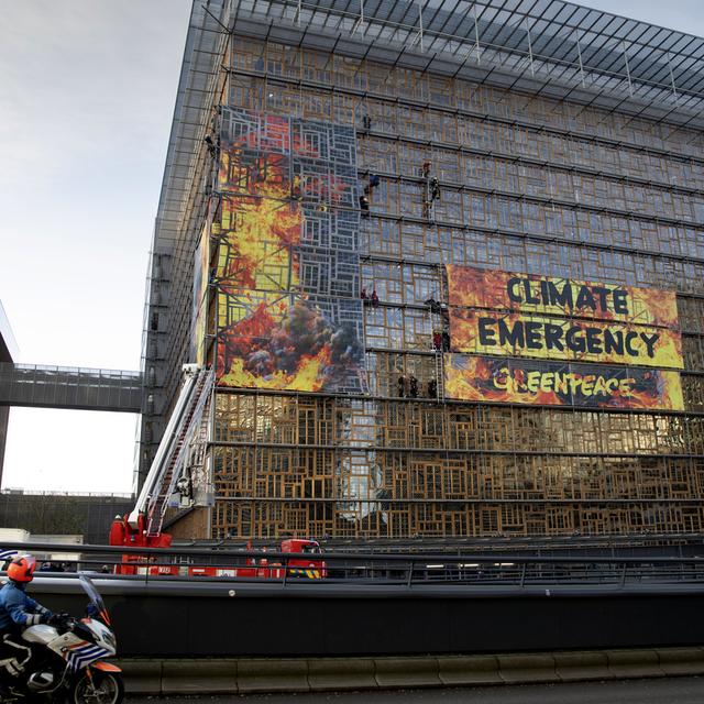 Des militants de Greenpeace ont déployé des banderoles sur le nouveau bâtiment du Conseil européen à Bruxelles. [Keystone/AP Photo - Virginia Mayo]