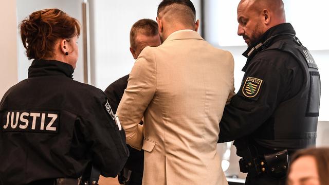 Des officiers de justice mènent l'accusé dans une salle d'audience pour le verdict [EPA - Filip Singer]