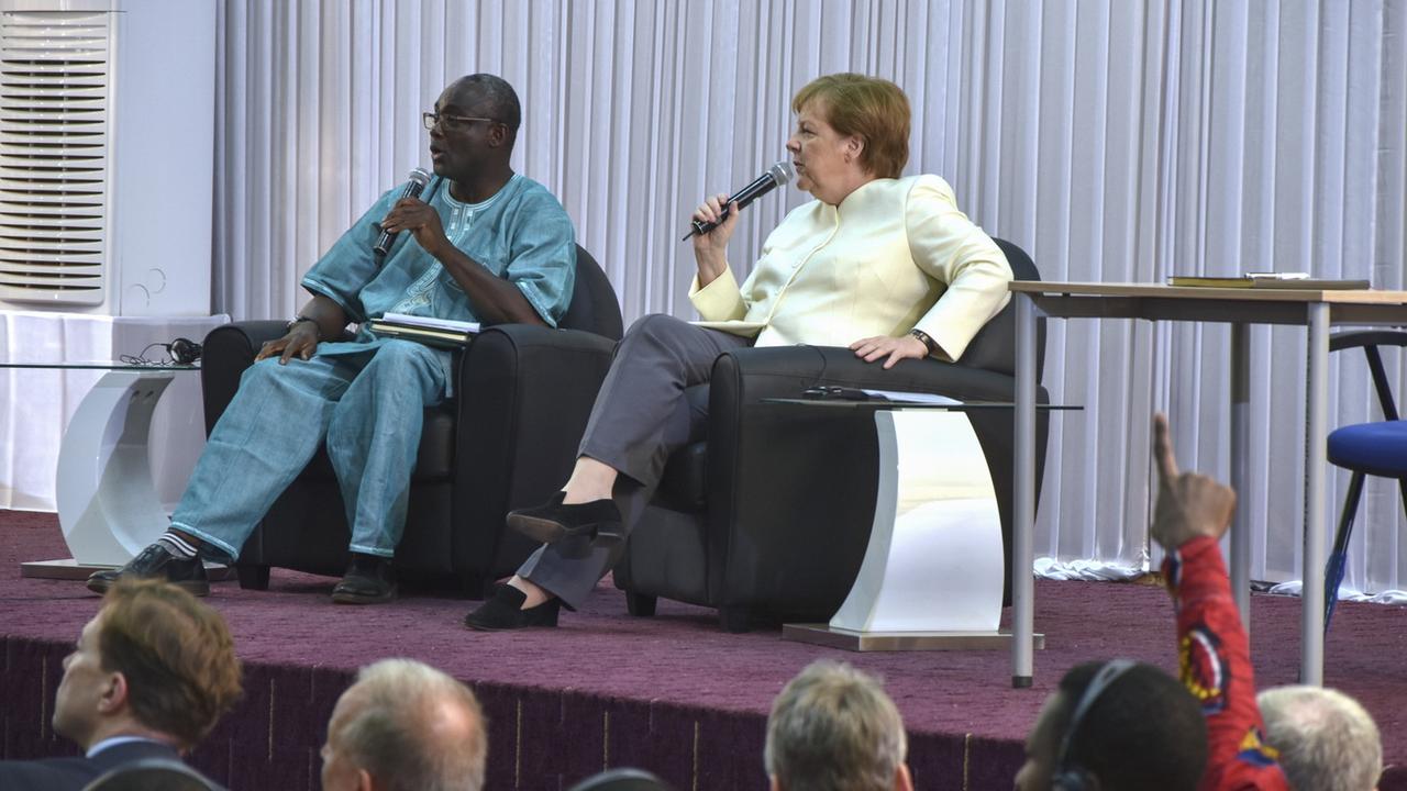 Angela Merkel (droite) dialogue avec les participants à une réunion à l'université de Ouagadougou, au Burkina Faso, ce 2 mai 2019.