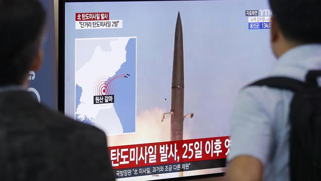 A la gare de Séoul, en Corée du Sud, des passants regardent les images du lancement d'un missile en Corée du Nord. [Keystone/AP - Ahn Young-joon]