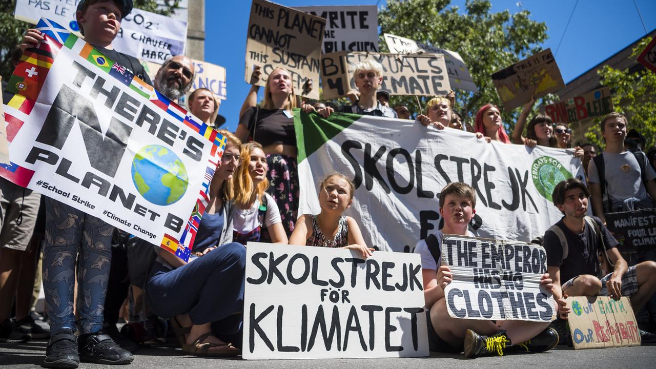 La militante suédoise Greta Thunberg, entourée d'autres jeunes activistes, lors d'une manifestation pour le climat à Lausanne le 9 août 2019. [Keystone - Jean-Christophe Bott]