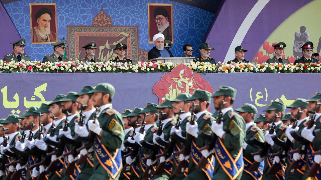Le président iranien Hassan Rohani passe en revue les troupes durant une parade militaire. [Keystone/EPA - Bureau présidentiel iranien]