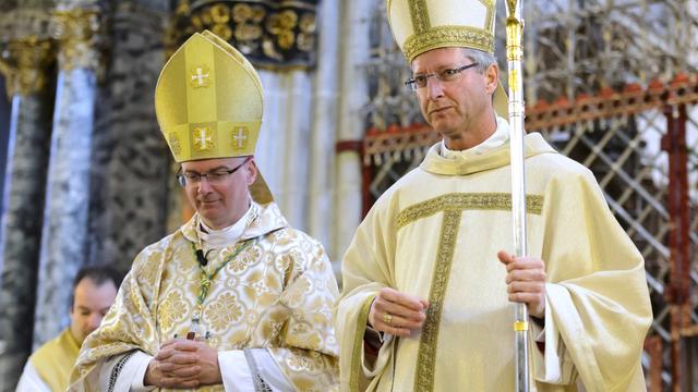 Alain de Raemy (droite), nouvel évêque auxiliaire du diocèse de Lausanne, Genève et Fribourg, lors de sa cérémonie d'ordination épiscopale, marche à côté de Charles Morerod (gauche), évêque du diocèse de Lausanne, Genève et Fribourg. Cathédrale Saint-Nicolas, Fribourg, le 11 janvier 2014. [Keystone - Laurent Gillieron]