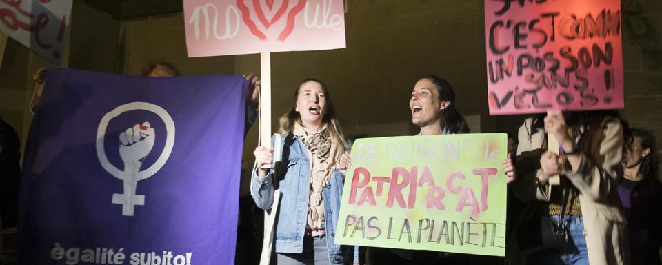 Des femmes manifestent au pied de la cathédrale de Lausanne pour lancer la journée de la grève des femmes. [Keystone - Laurent Gillieron]