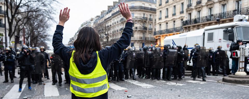 Une jeune femme s'avance vers les forces de police à Paris le 12 janvier 2019. [AFP - Karine Pierre / Hans Lucas]