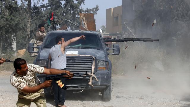 Des membres des forces loyales au gouvernement d'union nationale se battent contre les forces du maréchal Haftar, dans le quartier d'Ain Zara à Tripoli. [AFP - Mahmud Turkia]