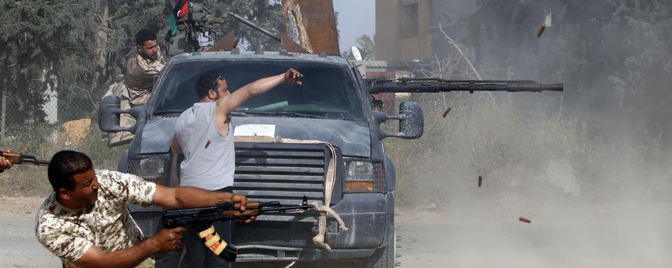 Des membres des forces loyales au gouvernement d'union nationale se battent contre les forces du maréchal Haftar, dans le quartier d'Ain Zara à Tripoli. [AFP - Mahmud Turkia]