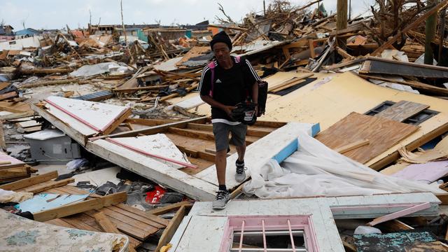 Un homme marche dans les débris du quartier de Mudd à Marsh Harbour, au nord de l'île de Great Abaco [Reuters - Marco Bello]