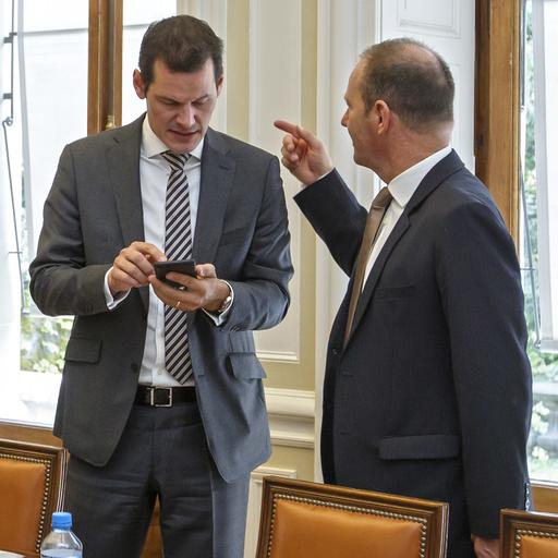 Pierre Maudet (gauche) et Serge Dal Busco (droite) discutent après la présentation du projet de budget 2019 de l'Etat de Genève, le 14 septembre 2018. [Keystone - Salvatore Di Nolfi]