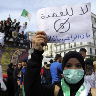 "Pas de cinquième mandat," est-il écrit en arabe sur la feuille brandie par cette manifestante, à Alger. [Keystone/ap - Anis Belghoul]