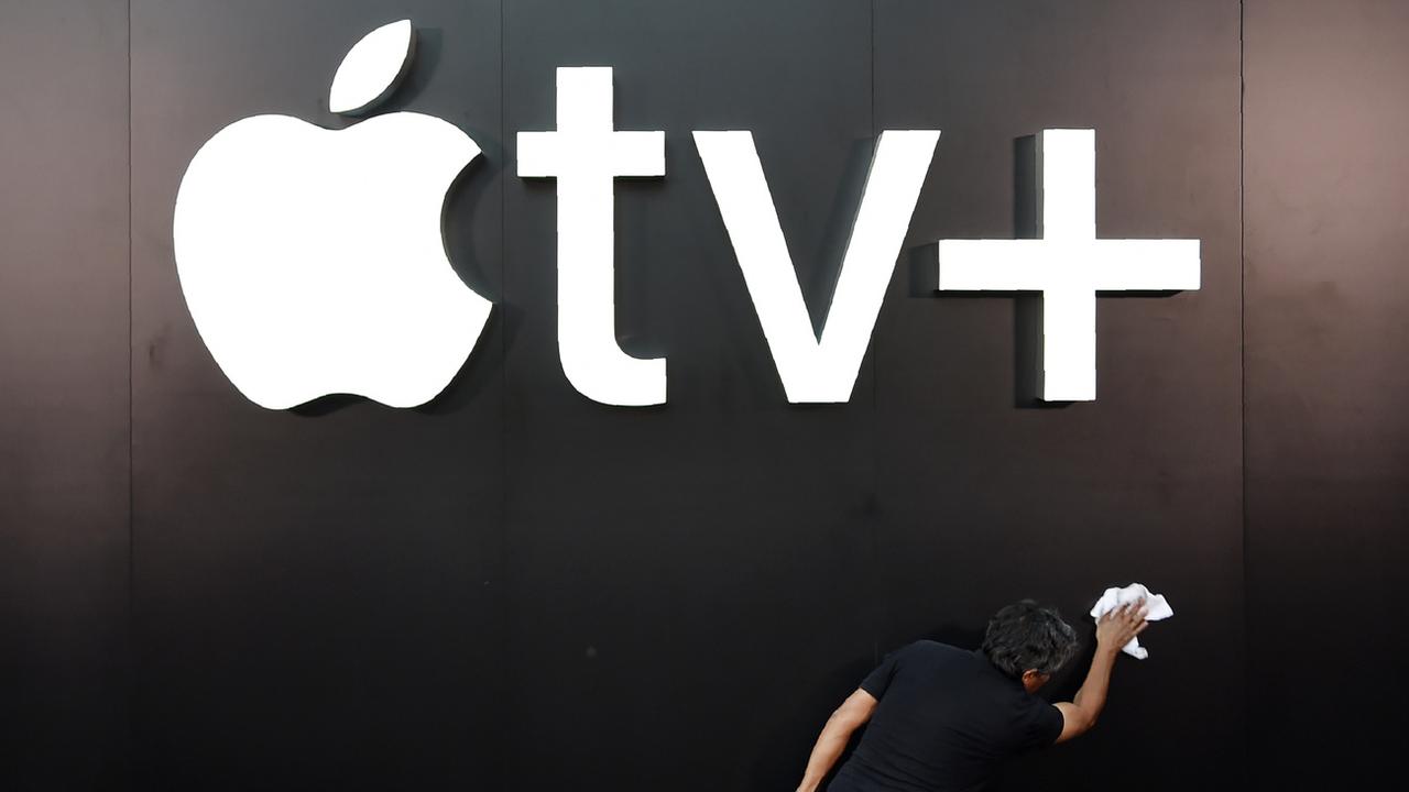 Un employé nettoie le logo d'Apple TV+ à Los Angeles, avant la présentation de la série "See". [Keystone - Chris Pizzello]