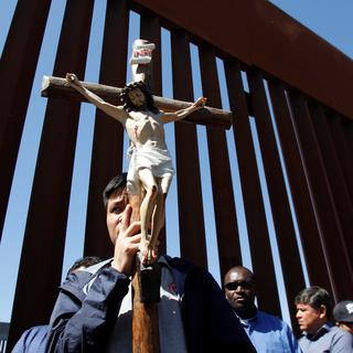 Un groupe de prêtres prient à la frontière entre Etats-Unis et Mexique à Tijuana. [Reuters - Jorge Duenes]