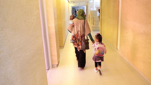 Une femme voilée accompagne ses enfants à l'école. [AFP - Nicolas Guyonnet / Hans Lucas]