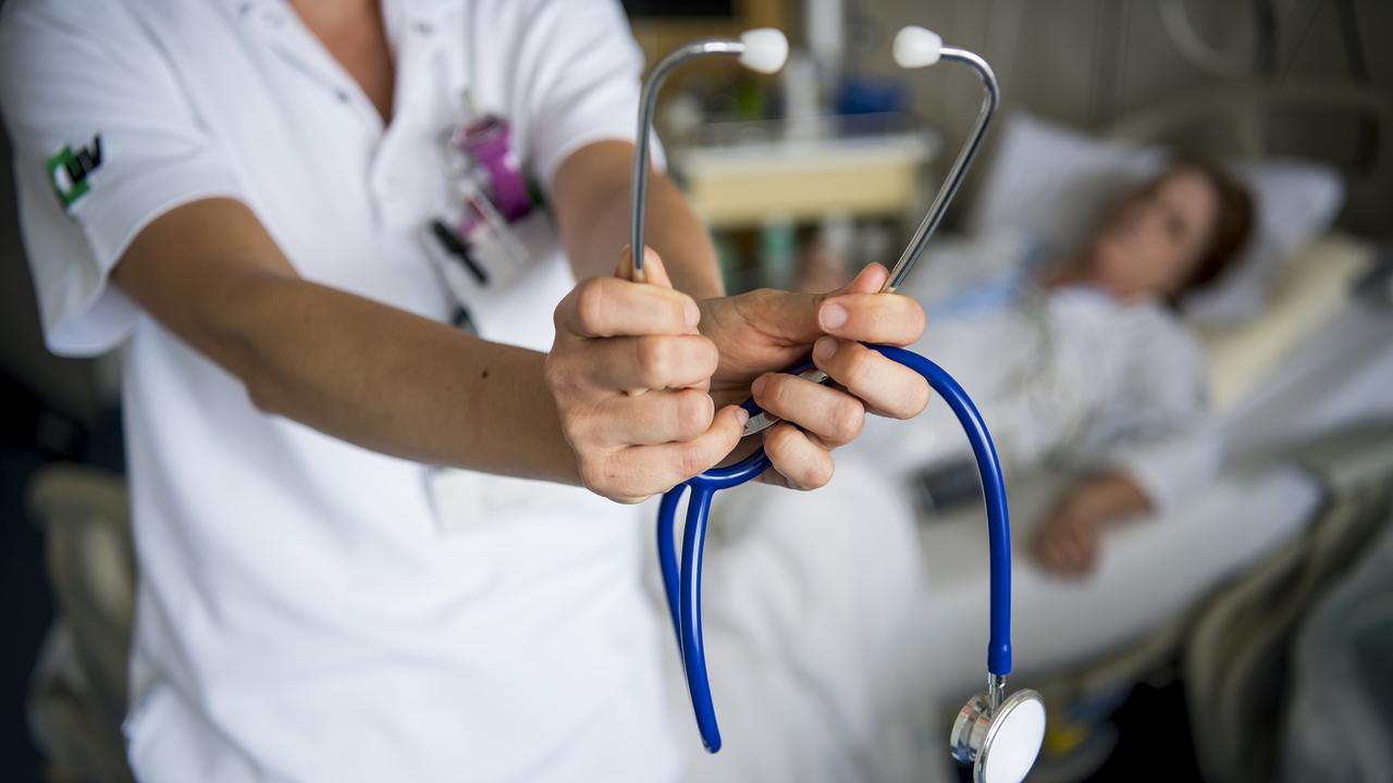 Une infirmière tient un stéthoscope devant une patiente dans une chambre du CHUV à Lausanne. (Image d'illustration). [KEYSTONE - JEAN-CHRISTOPHE BOTT]