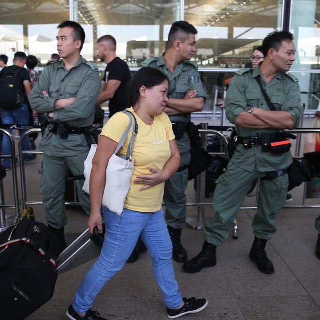 Des gardes de sécurité contrôlent les accès à l'aéroport international de Hong Kong. [Keystone - Jerome Favre]