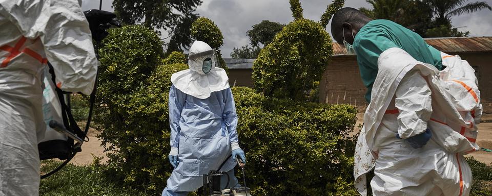 Une équipe médicale désinfecte l'habitation d'un patient, transféré dans un centre de traitement Ebola au Nord-Kivu. [EPA/Keystone - Hugh Kinsella Cunningham]