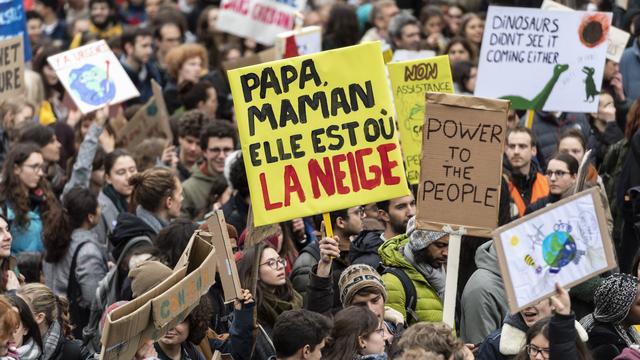 Un manifestant lausannois esquisse un futur inquiétant sur sa pancarte. [KEYSTONE - Jean-Christophe Bott]