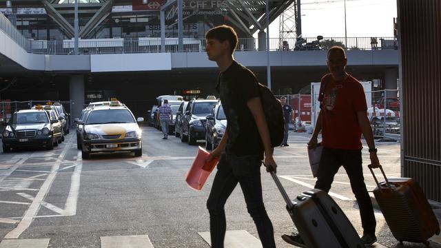 Des passagers devant la station de taxis de l'aéroport de Genève (image d'illustration). [Keystone - Salvatore Di Nolfi]