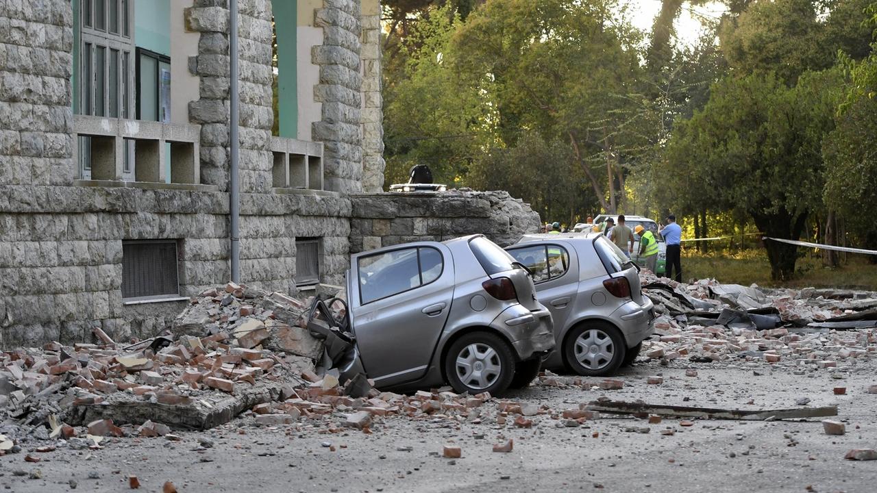 Des voitures ont été endommagées par des chutes de pierres à Tirana. [Keystone - AP Photo/Hektor Pustina]