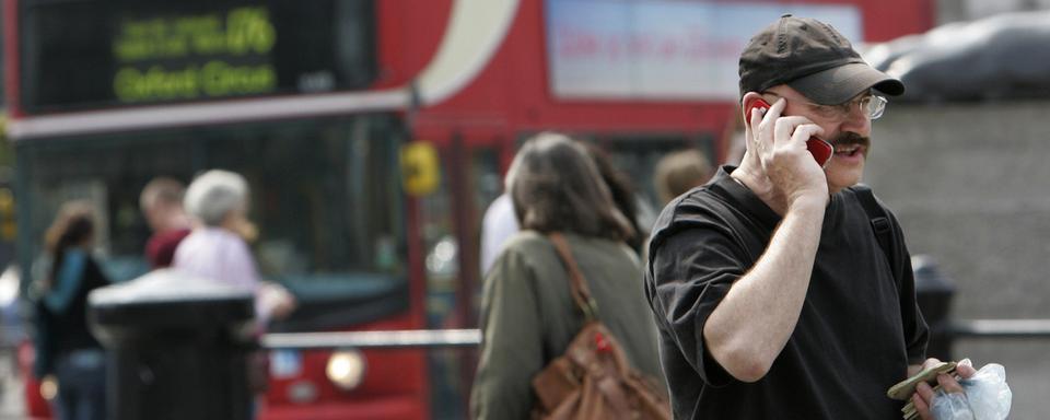 Une personne au téléphone à Trafalgar Square, dans le centre-ville de Londres. (image d'illustration) [Keystone - Lefteris Pitarakis]