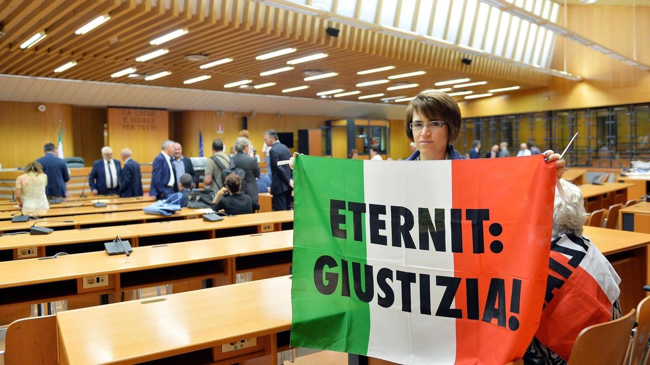 Une personne proche d'une des victimes de l'amiante tient un drapeau sur lequel est inscrit "Eternit: justice" lors du procès à Turin de Stephan Schmidheiny en 2015.