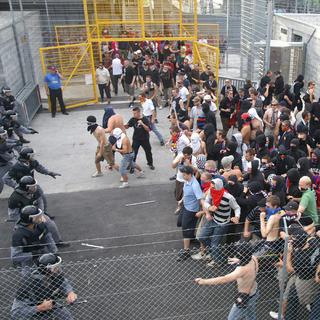 Des fans ultras face à la police lors d'un match entre Sion et Bâle. [Keystone - Kantonspolizei Wallis]