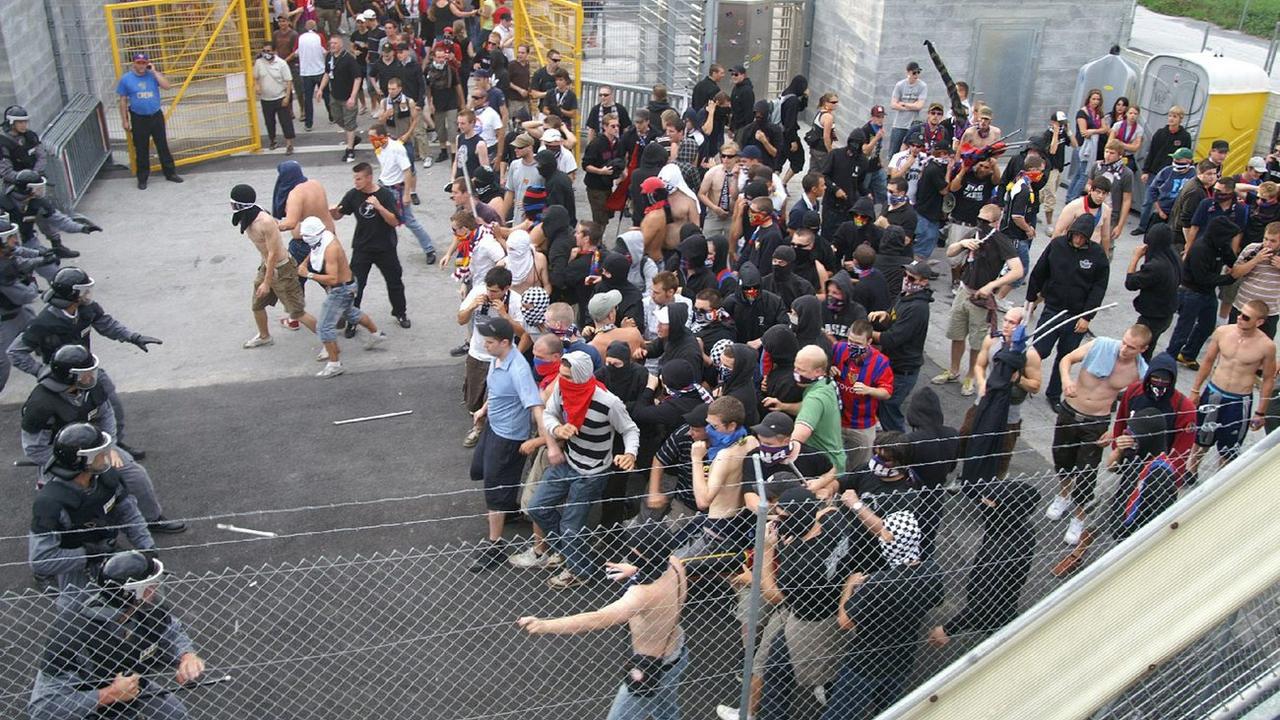 Des fans ultras face à la police lors d'un match entre Sion et Bâle. [Keystone - Kantonspolizei Wallis]