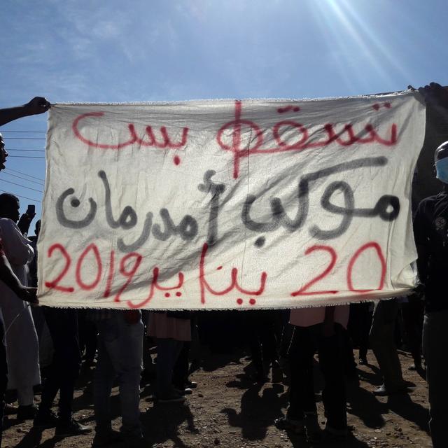 Des personnes brandissent une banière demandant un changement de régime lors d'une manifestation anti-gouvernementale à Omdurman au Soudan. [Stringer/AFP]
