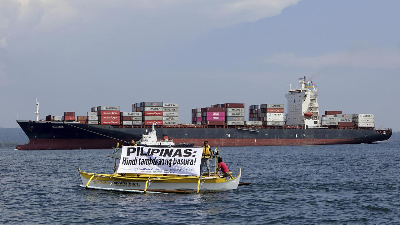 "Les Philippines ne sont pas un dépotoir!", c'est ce que dit ce panneau, devant un cargo qui renvoie plusieurs tonnes de déchets expédiés par le Canada. [Keystone /AP]