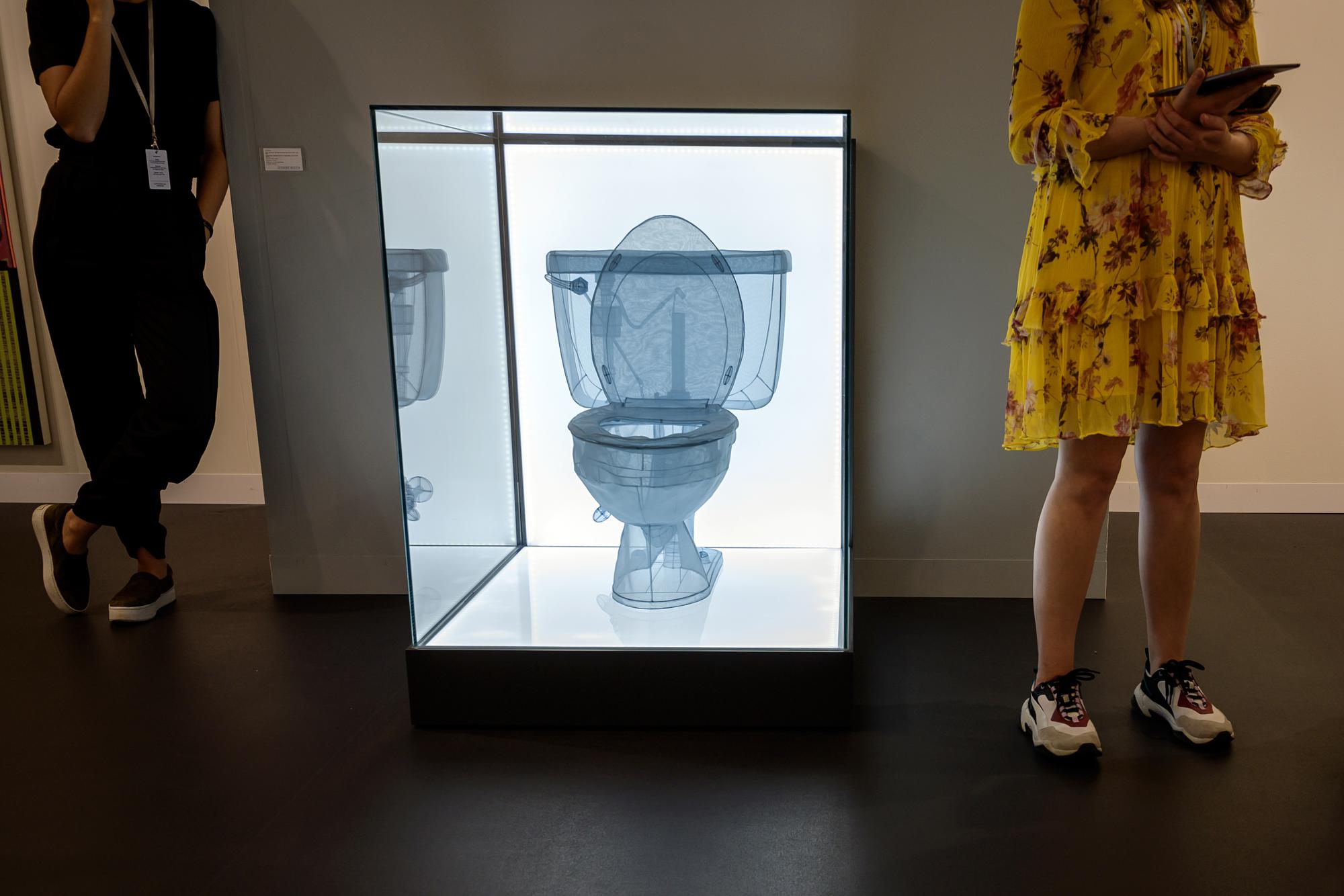 Des visiteurs regardent l'oeuvre de l'artiste Do Ho Suh "Toilet, Apartment A, 348 West 22nd Street, New York, NY 10011, USA" à la Galerie  Lehmann Maupin à Basel. [AFP - FABRICE COFFRINI]